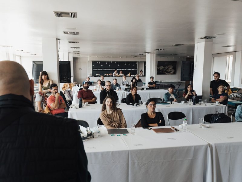 A large group of staff seated at tables during a training session in a conference room